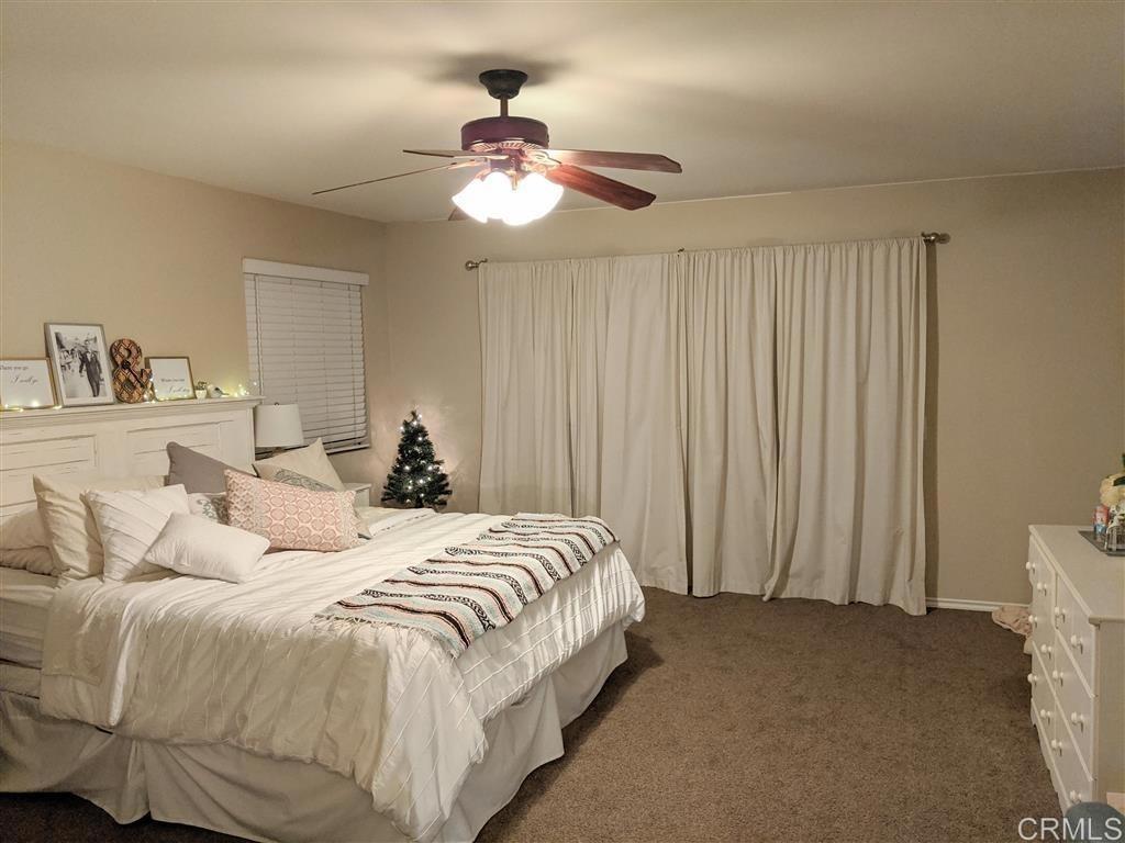 31908 Del Cielo Este, Unit 3A Bonsall, CA 92003 - Photo 7 of 8 a bedroom with a bed and a chandelier