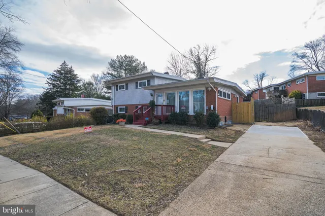 a front view of a house with a yard and trees