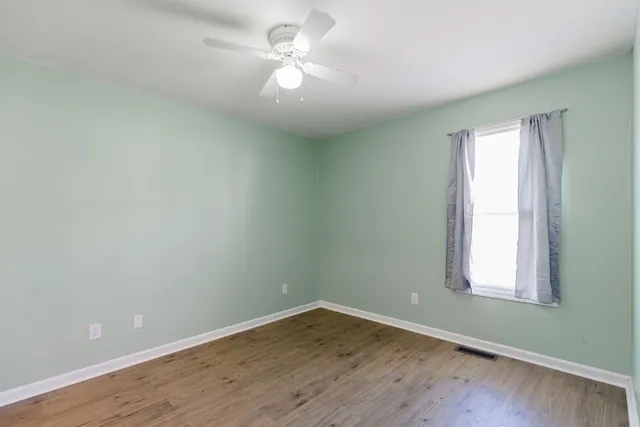 an empty room with wooden floor and closet