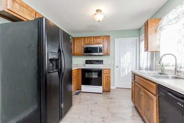 a kitchen with stainless steel appliances granite countertop a refrigerator and a sink
