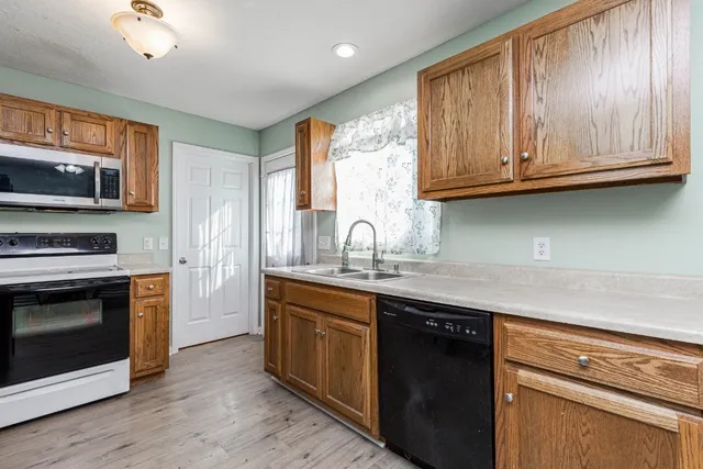 a kitchen with stainless steel appliances granite countertop a sink a stove and a microwave
