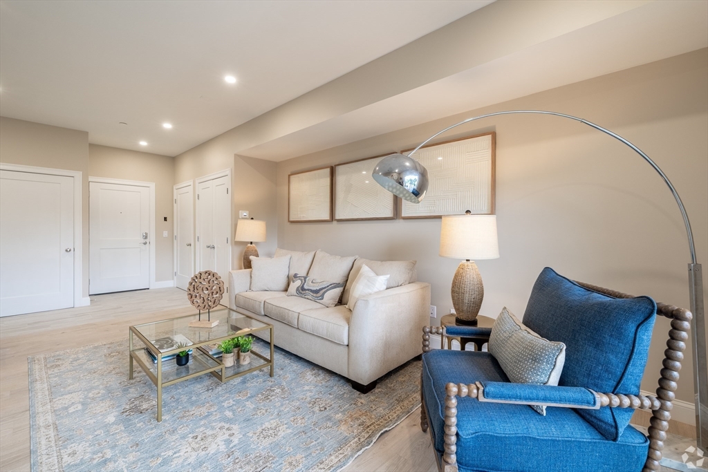 69 East Central Street, Unit 305 Natick, MA 01760 - Photo 2 of 11 a living room with furniture and wooden floor