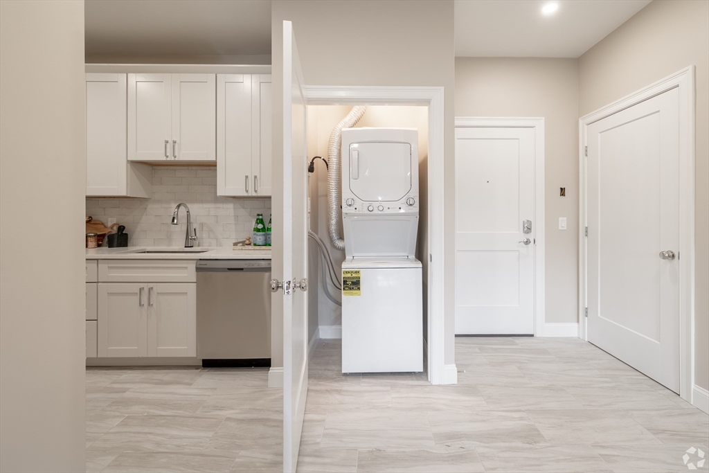 69 East Central Street, Unit 305 Natick, MA 01760 - Photo 6 of 11 a kitchen with white cabinets and refrigerator