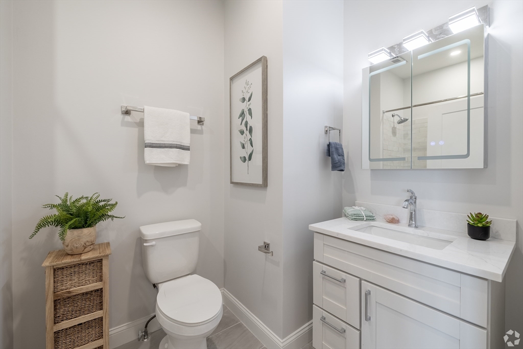 69 East Central Street, Unit 305 Natick, MA 01760 - Photo 7 of 11 a bathroom with a toilet sink and mirror