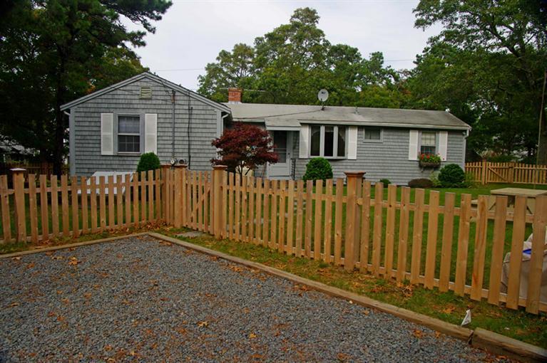 169 Foster Road Brewster, MA 02631 - Photo 3 of 14 a front view of a house with a garden