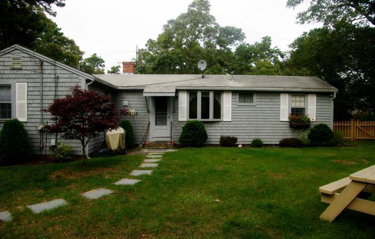 169 Foster Road Brewster, MA 02631 - Photo 5 of 14 a front view of a house with a garden