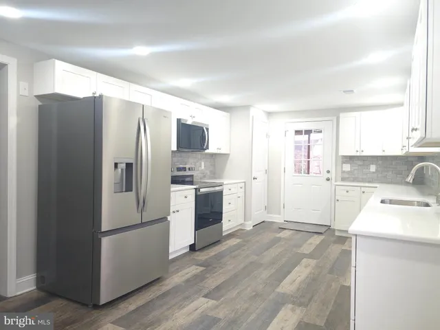 a kitchen with a refrigerator sink and cabinets