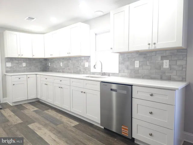 a kitchen with granite countertop white cabinets white appliances and a sink