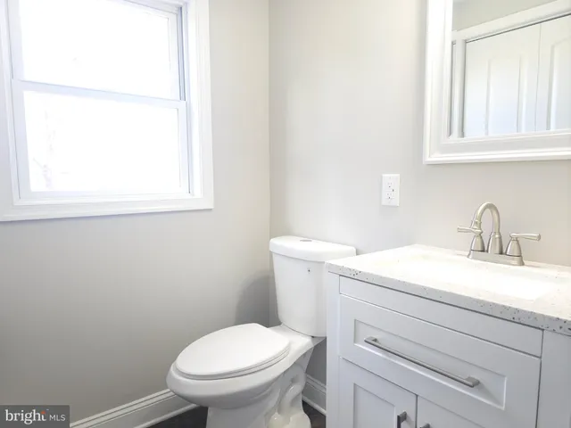 a bathroom with a sink a toilet and a window