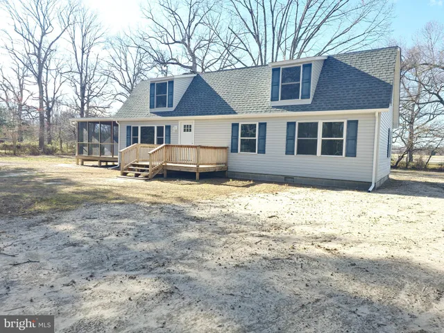 a front view of a house with a yard covered with snow