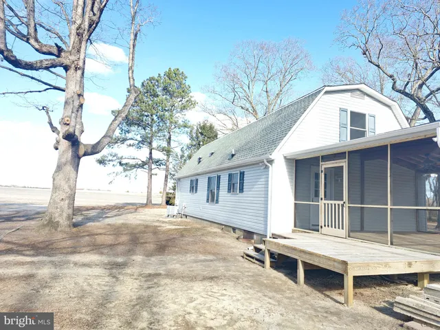 a view of a white house with a large tree