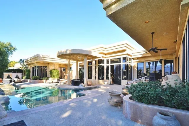 a view of a patio with table and chairs potted plants and palm tree