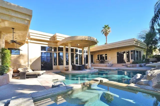 a view of a patio with table and chairs potted plants and palm tree