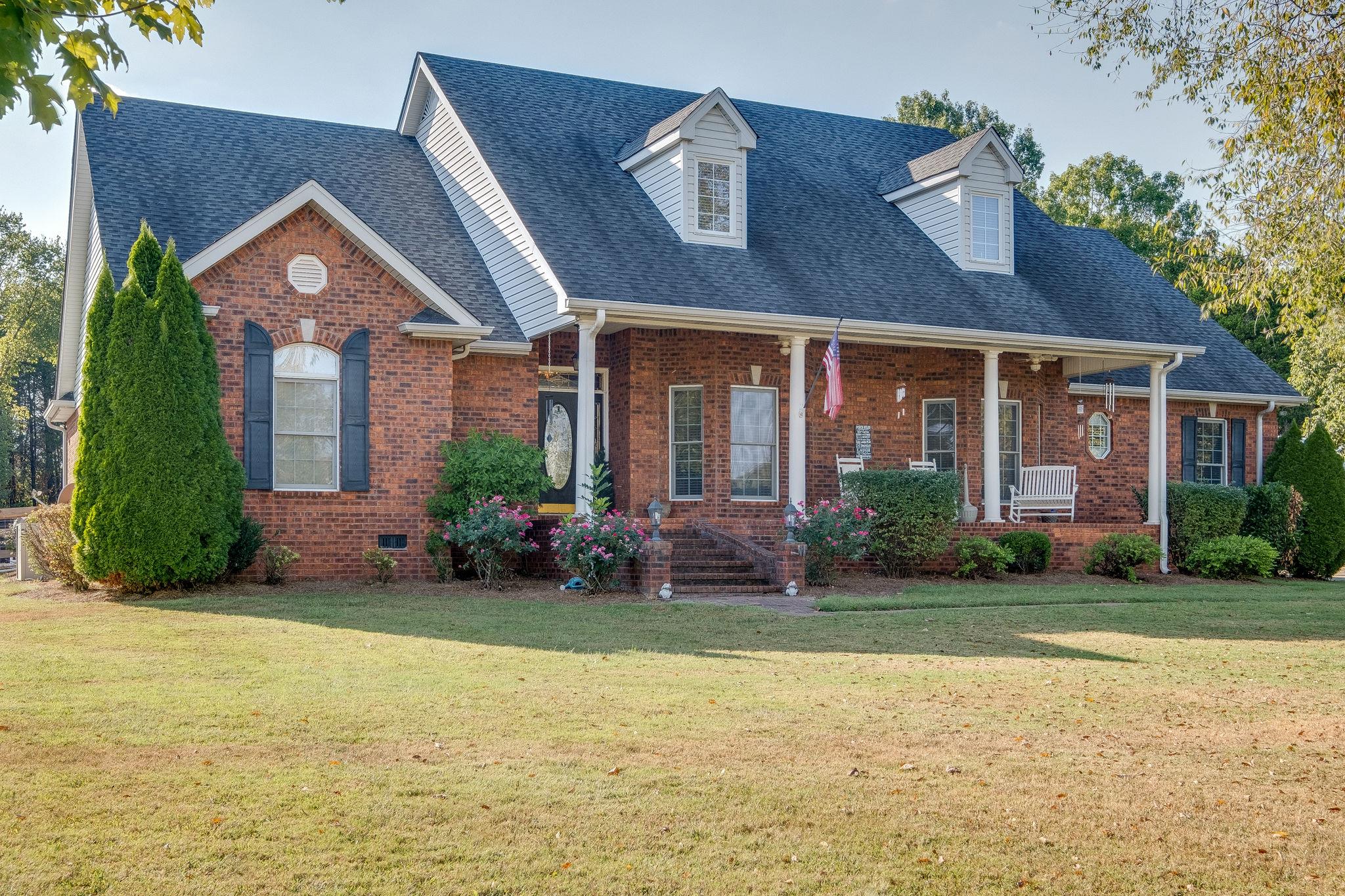 a front view of a house with a garden and plants