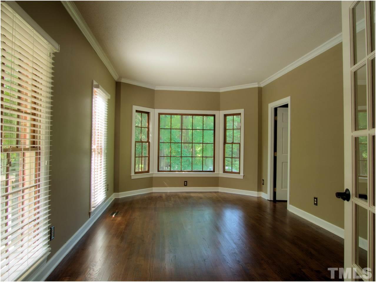 4709 Fallswood Place Raleigh, NC 27613 - Photo 11 of 25 a view of an empty room with wooden floor and a window