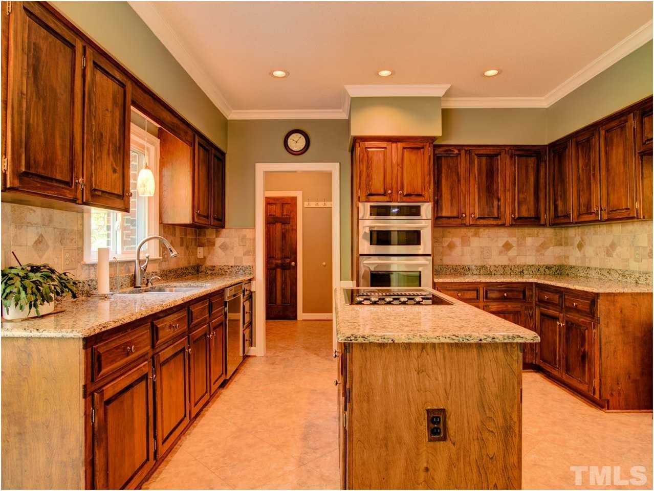 4709 Fallswood Place Raleigh, NC 27613 - Photo 14 of 25 a kitchen with stainless steel appliances granite countertop a sink stove and cabinets