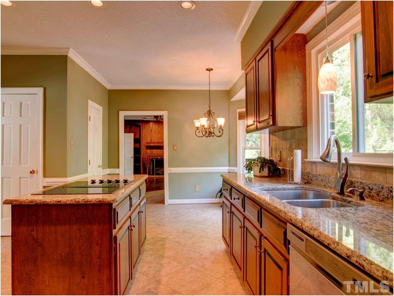 4709 Fallswood Place Raleigh, NC 27613 - Photo 15 of 25 a kitchen with kitchen island granite countertop a sink and a large window