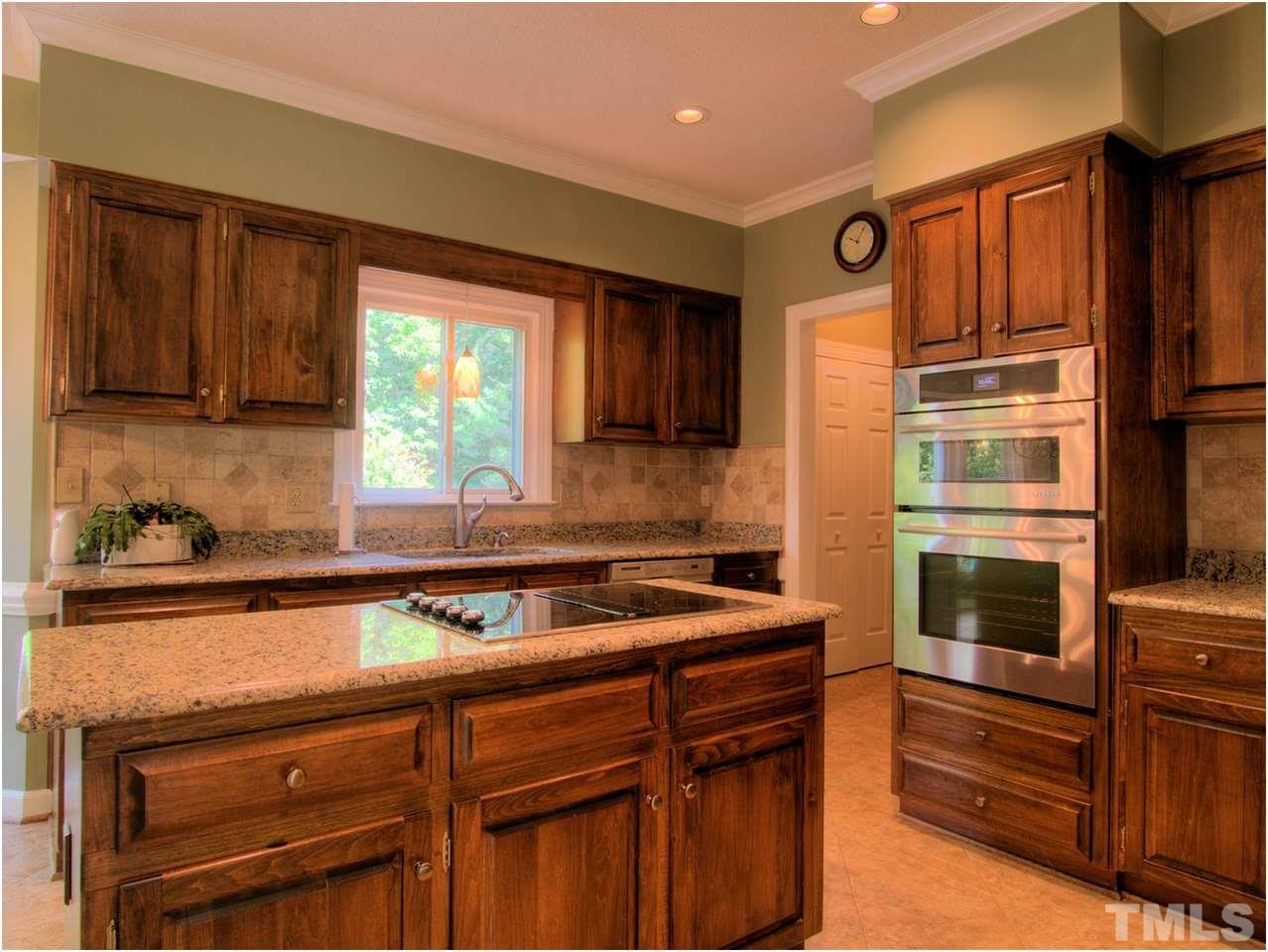 4709 Fallswood Place Raleigh, NC 27613 - Photo 16 of 25 a kitchen with stainless steel appliances granite countertop a sink stove and microwave