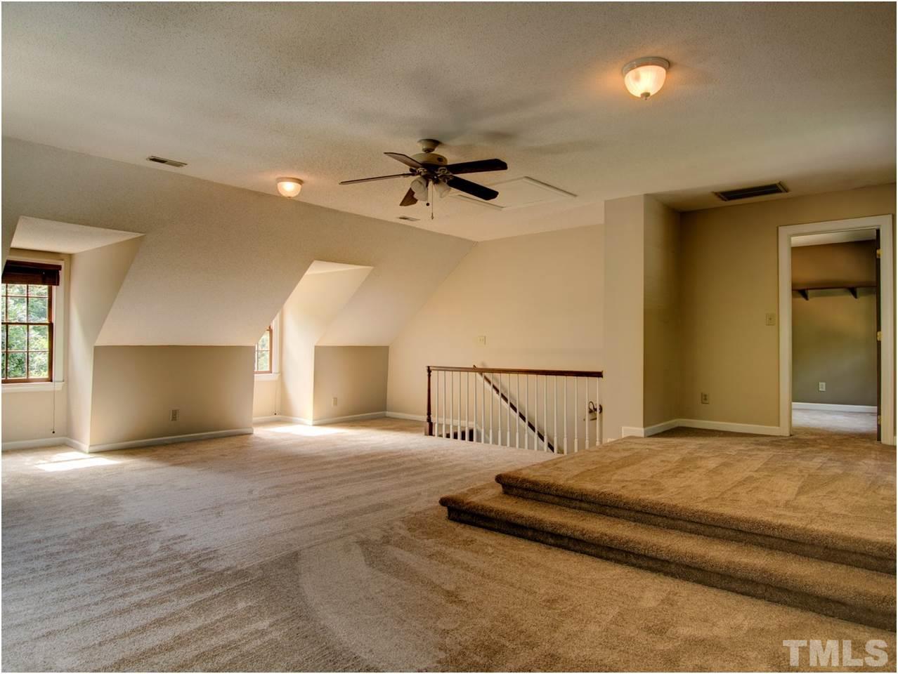 4709 Fallswood Place Raleigh, NC 27613 - Photo 21 of 25 a view of a bedroom with a bed and a chandelier fan