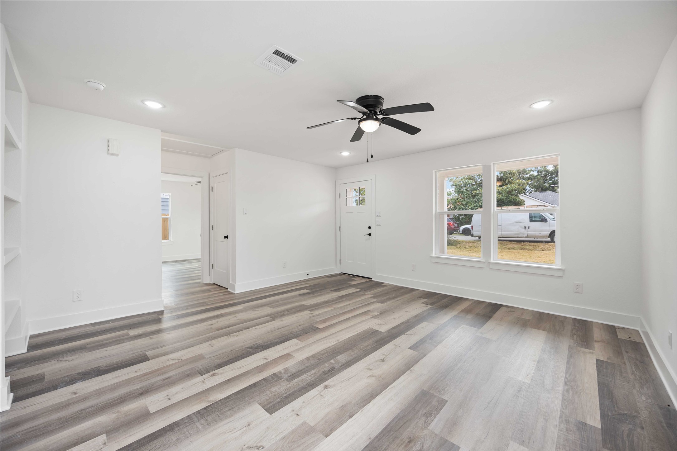 3405 Mt Pleasant Street Houston, TX 77021 - Photo 3 of 20 Discover seamless living in this bright space, showing off expansive windows and a welcoming entryway. To the left is the built-in shelving for smart storage solutions.
