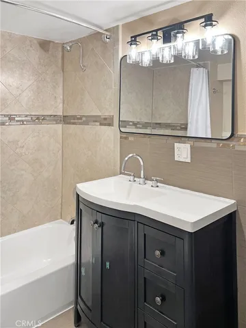 a view of an empty room with wooden floor ceiling fan