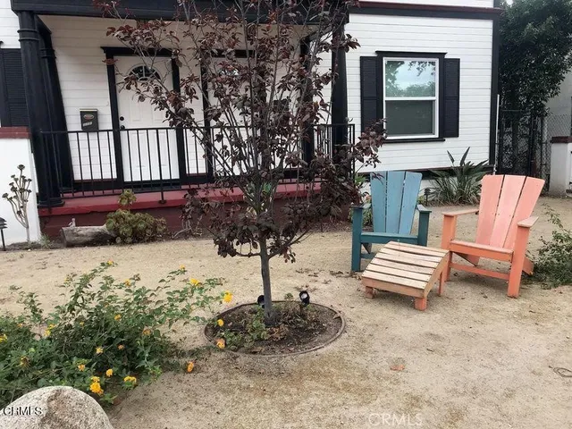 a view of a house with a yard and sitting area