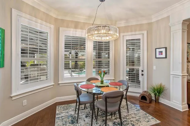 a dining room with furniture a chandelier and wooden floor