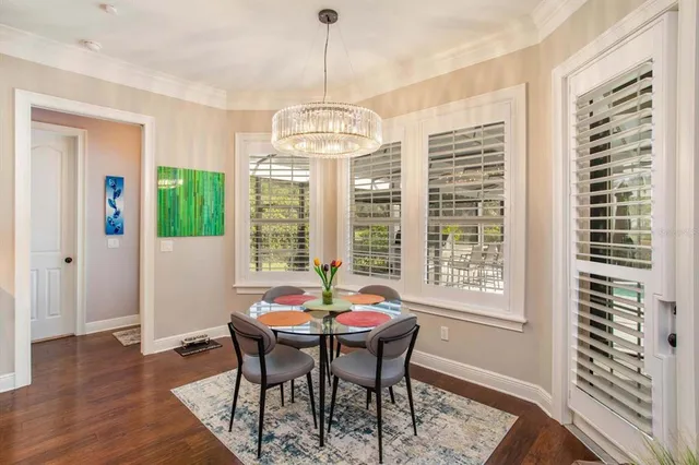 a dining room with furniture a chandelier and wooden floor
