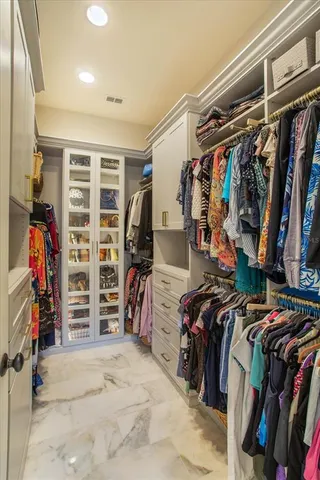 a view of walk in closet with clothes and shoes