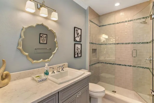 a bathroom with a sink a toilet and shower