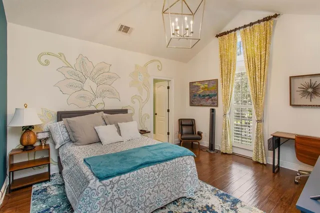 a bedroom with a bed wooden floor and table
