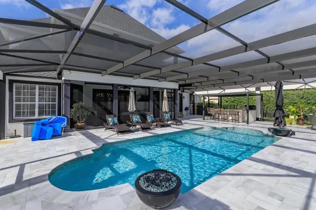 a view of a backyard with table and chairs potted plants and floor to ceiling window and stairs