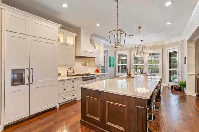 a kitchen with stainless steel appliances granite countertop a sink a stove and a refrigerator