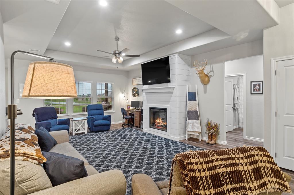 141 Walnut Street Paradise, TX 76073 - Photo 2 of 23 Living room featuring a tray ceiling, ceiling fan, wood finished floors, recessed lighting, and a large fireplace