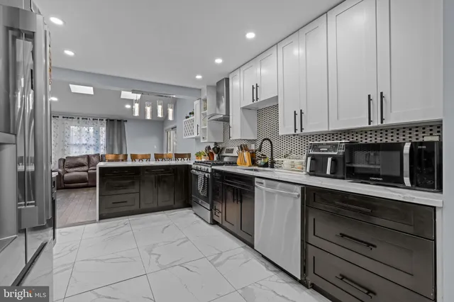 a kitchen with stainless steel appliances kitchen island granite countertop a stove a sink and a refrigerator