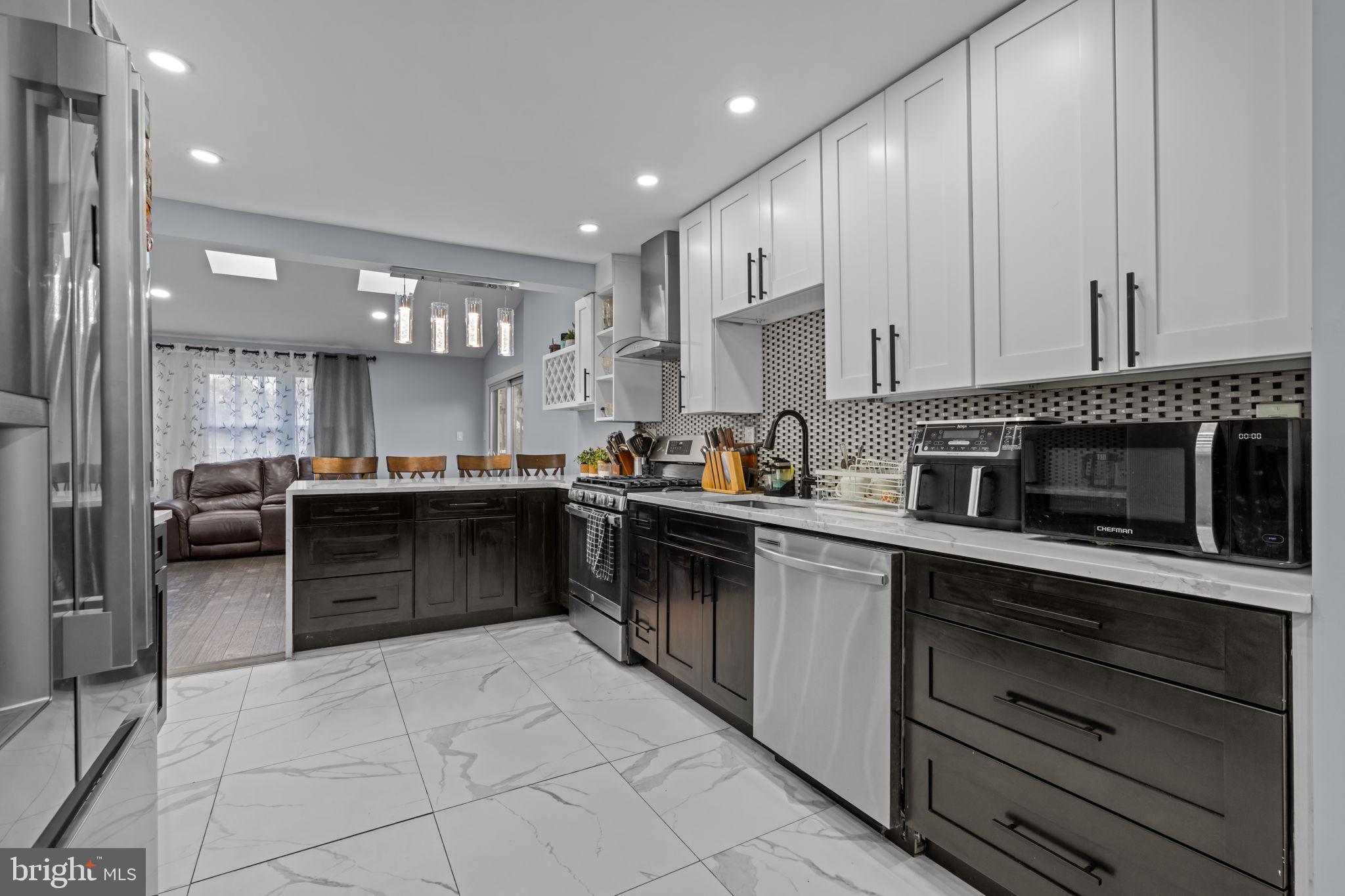 245 Trenton Road Fairless Hills, PA 19030 - Photo 11 of 43 a kitchen with stainless steel appliances kitchen island granite countertop a stove a sink and a refrigerator