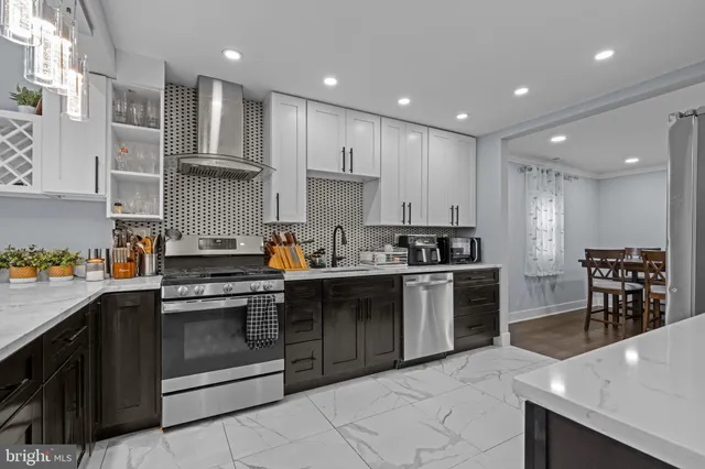 a kitchen with stainless steel appliances granite countertop a stove top oven a sink dishwasher and white cabinets