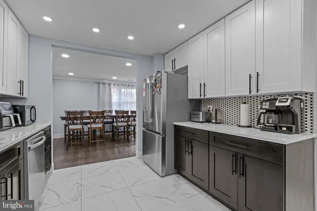 a kitchen with stainless steel appliances granite countertop a stove a sink a oven a dining table and chairs