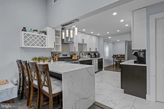 a kitchen with stainless steel appliances kitchen island granite countertop a table and chairs in it