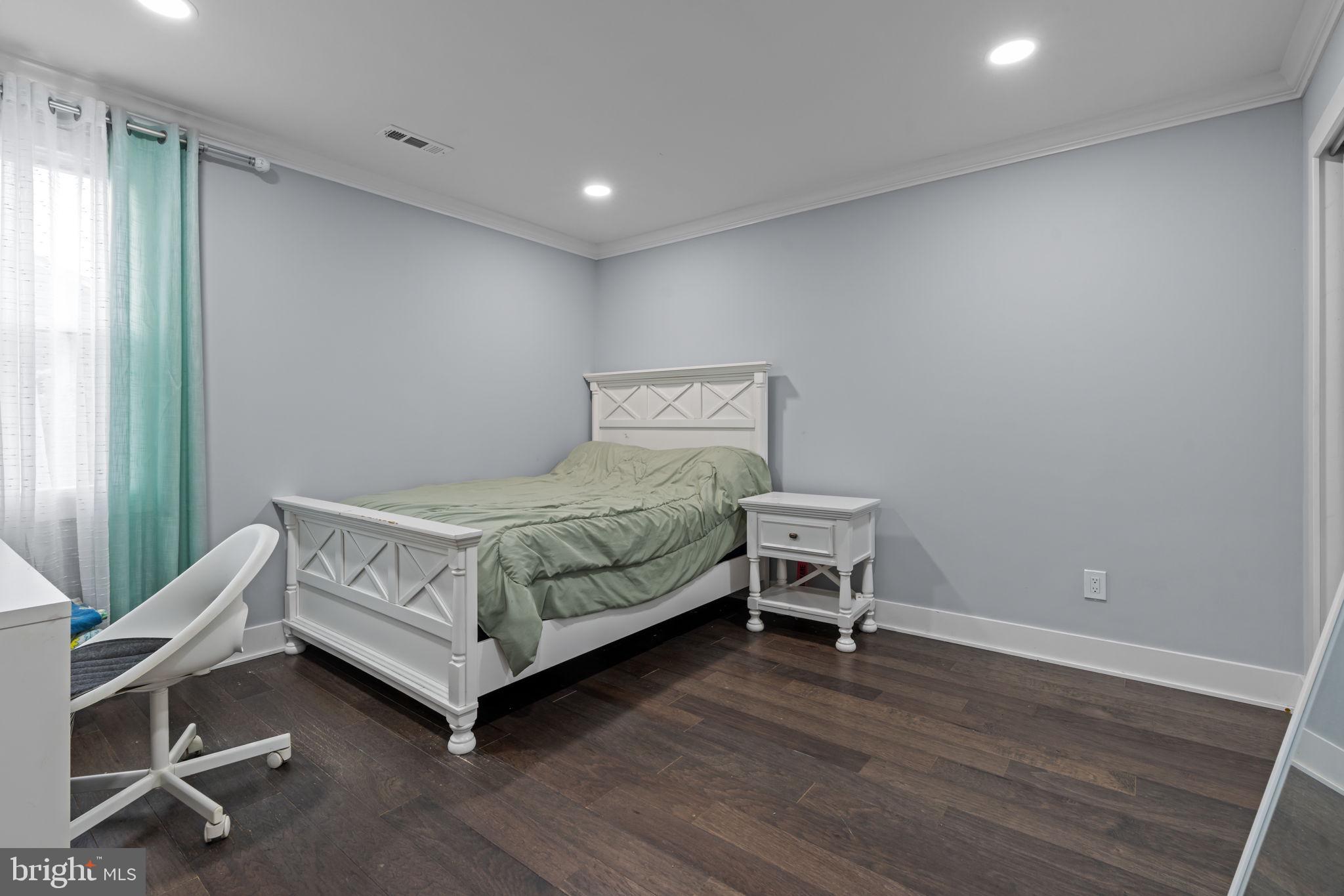 245 Trenton Road Fairless Hills, PA 19030 - Photo 9 of 43 a bedroom with a bed and a chair in it