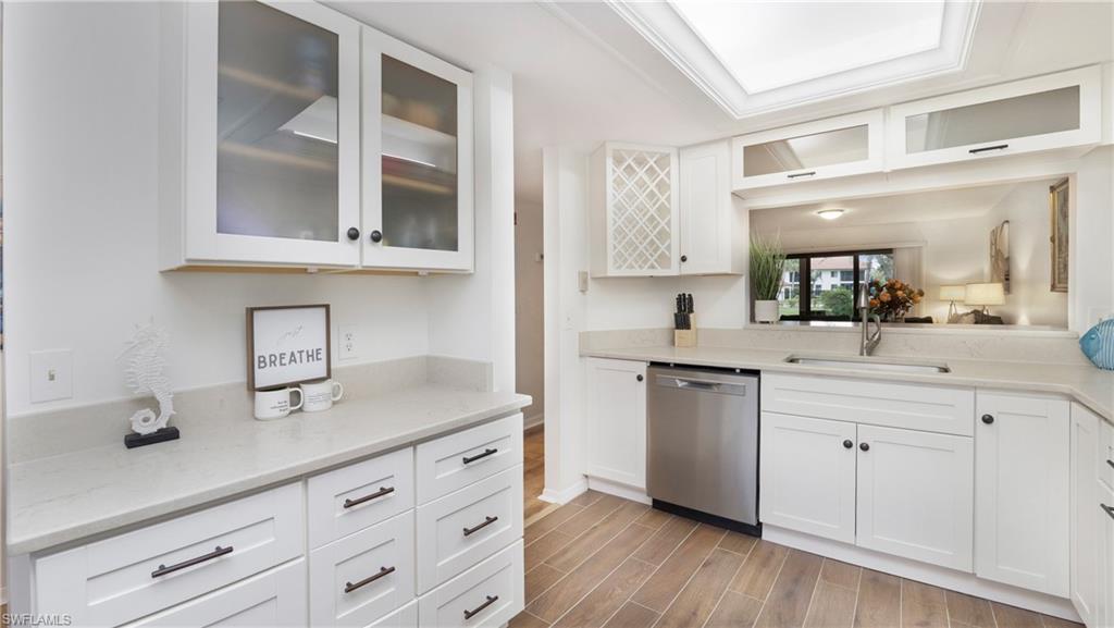 4957 Pepper Circle, Unit C104 Naples, FL 34113 - Photo 1 of 22 a kitchen with granite countertop white cabinets and white appliances