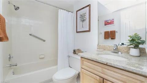 a bathroom with a granite countertop sink a toilet and a bathtub
