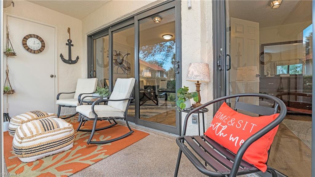 4957 Pepper Circle, Unit C104 Naples, FL 34113 - Photo 16 of 22 a living room with furniture a rug and a chandelier