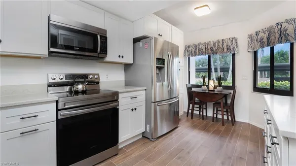 a kitchen with stainless steel appliances a stove microwave and refrigerator