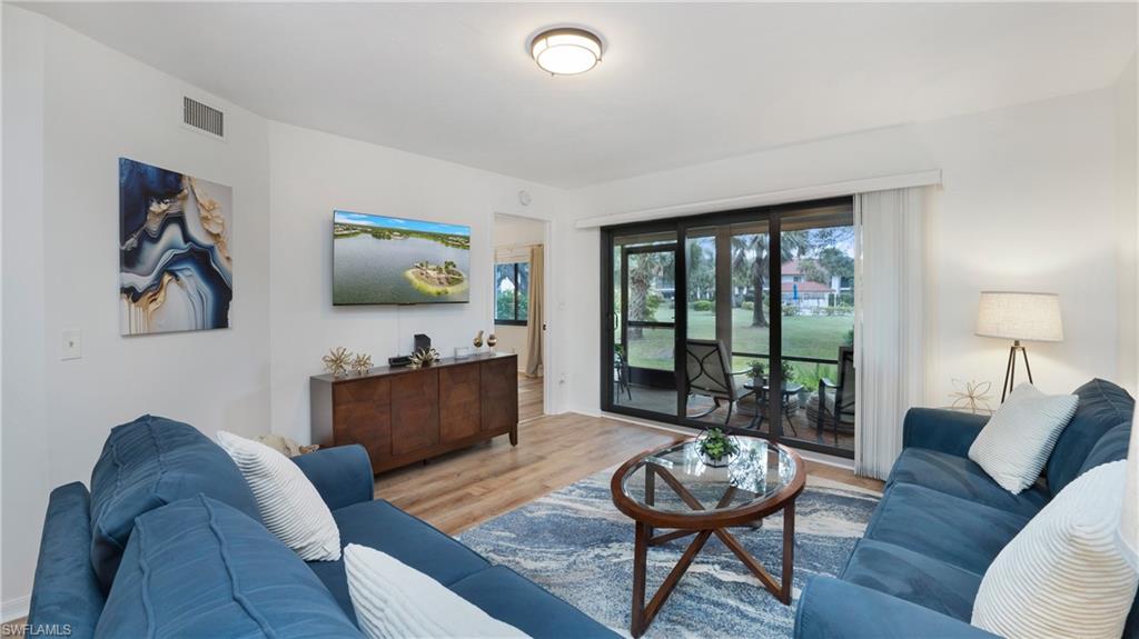4957 Pepper Circle, Unit C104 Naples, FL 34113 - Photo 3 of 22 a living room with furniture and a large window
