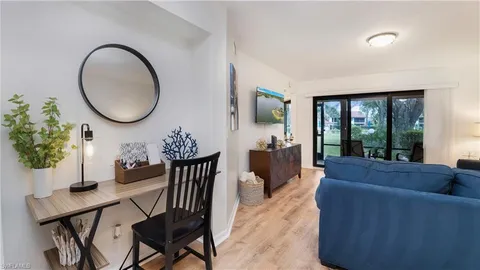 a living room with furniture a potted plant and a large window
