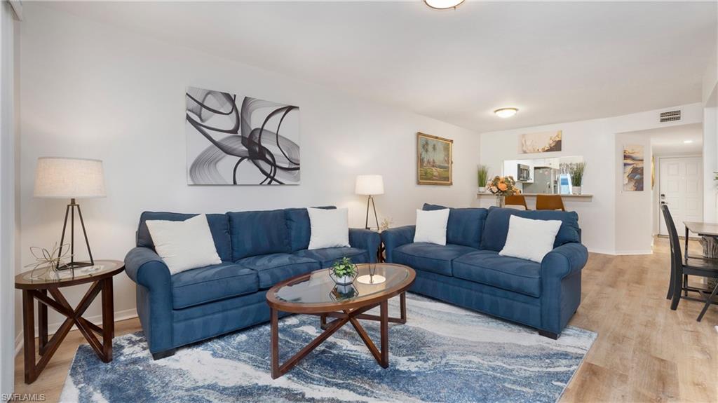 4957 Pepper Circle, Unit C104 Naples, FL 34113 - Photo 5 of 22 a living room with furniture and a lamp