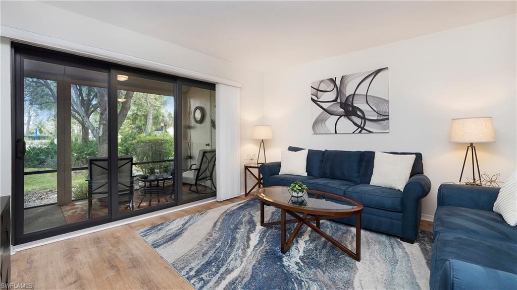 4957 Pepper Circle, Unit C104 Naples, FL 34113 - Photo 6 of 22 a living room with furniture and a large window