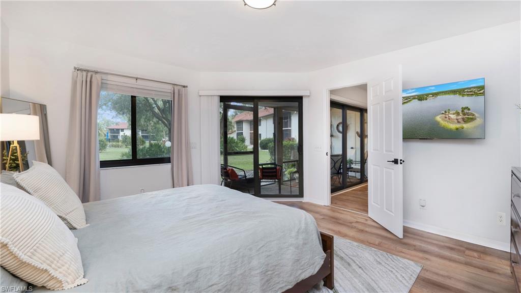 4957 Pepper Circle, Unit C104 Naples, FL 34113 - Photo 10 of 22 a bedroom with a bed and a large window