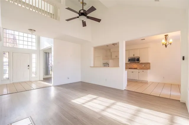 a view of a big room with wooden floor and a kitchen space